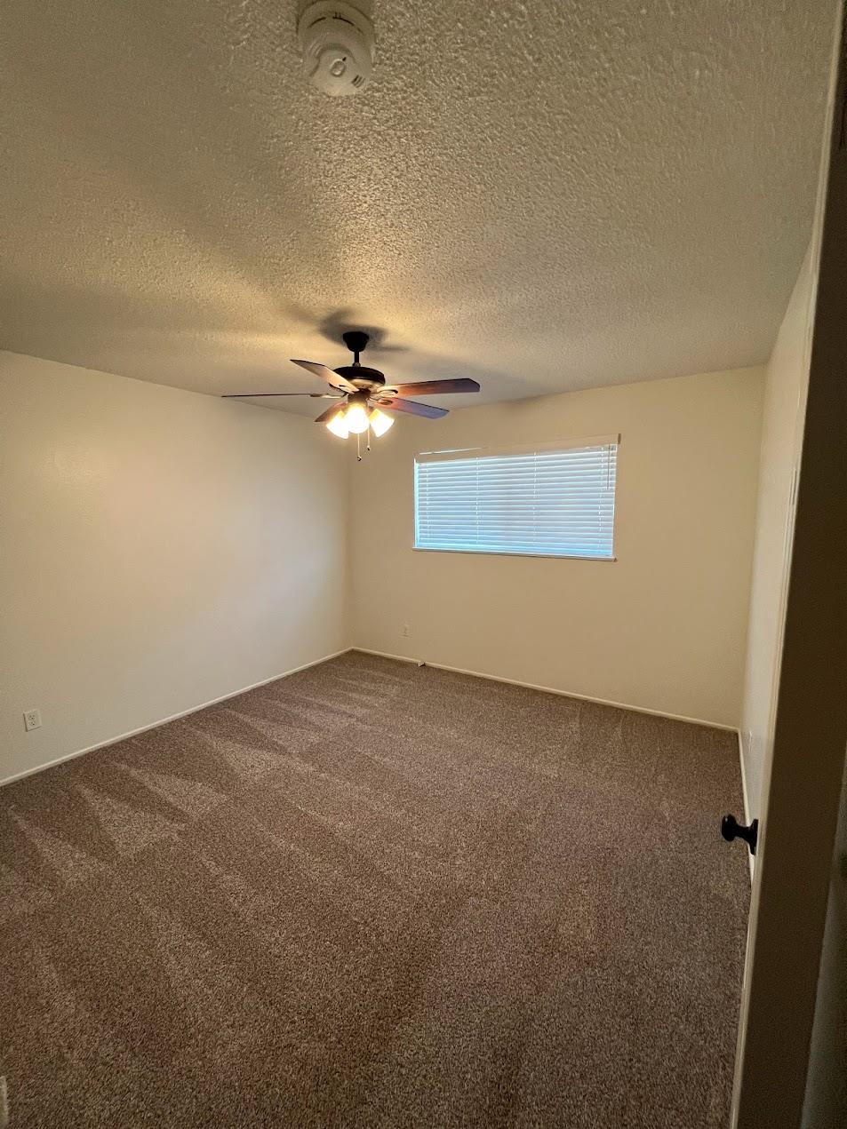 1205 F Street Reedley, CA 93654 - Photo 13 of 34 an empty room with a fan & a window