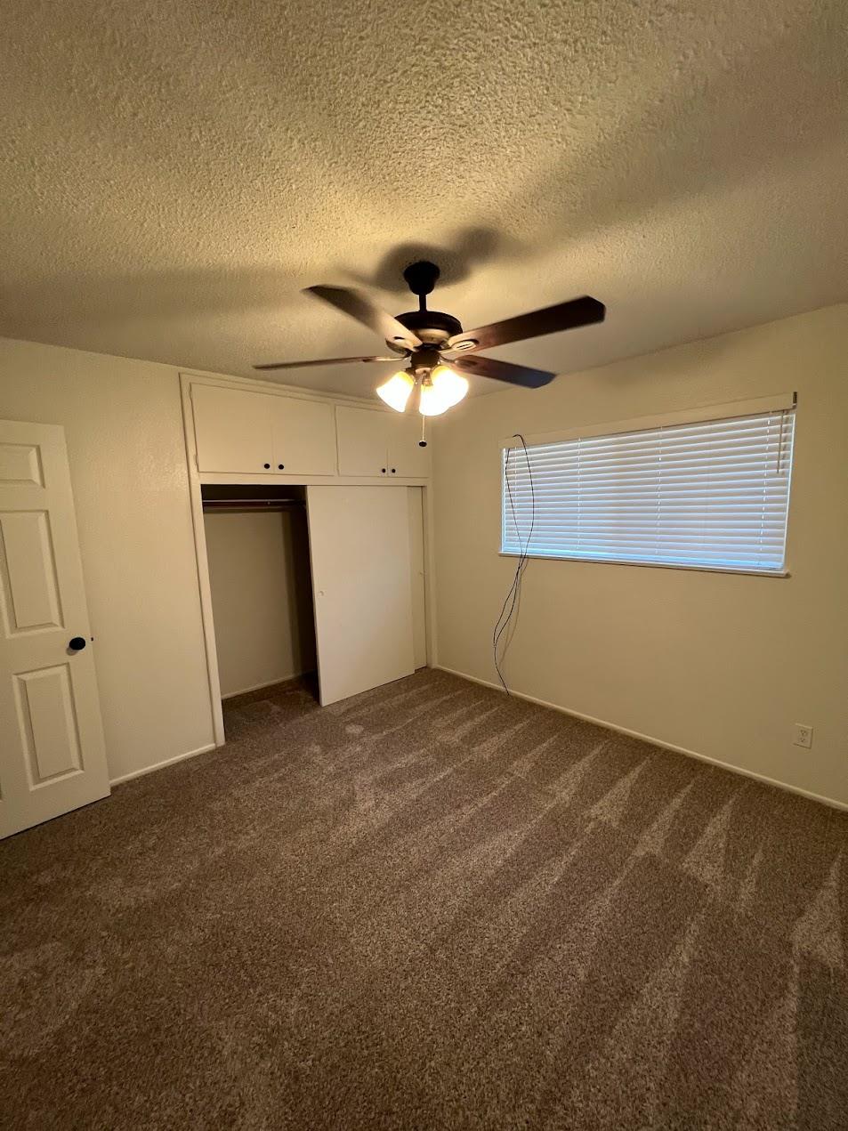 1205 F Street Reedley, CA 93654 - Photo 14 of 34 an empty room with a ceiling fan and a window