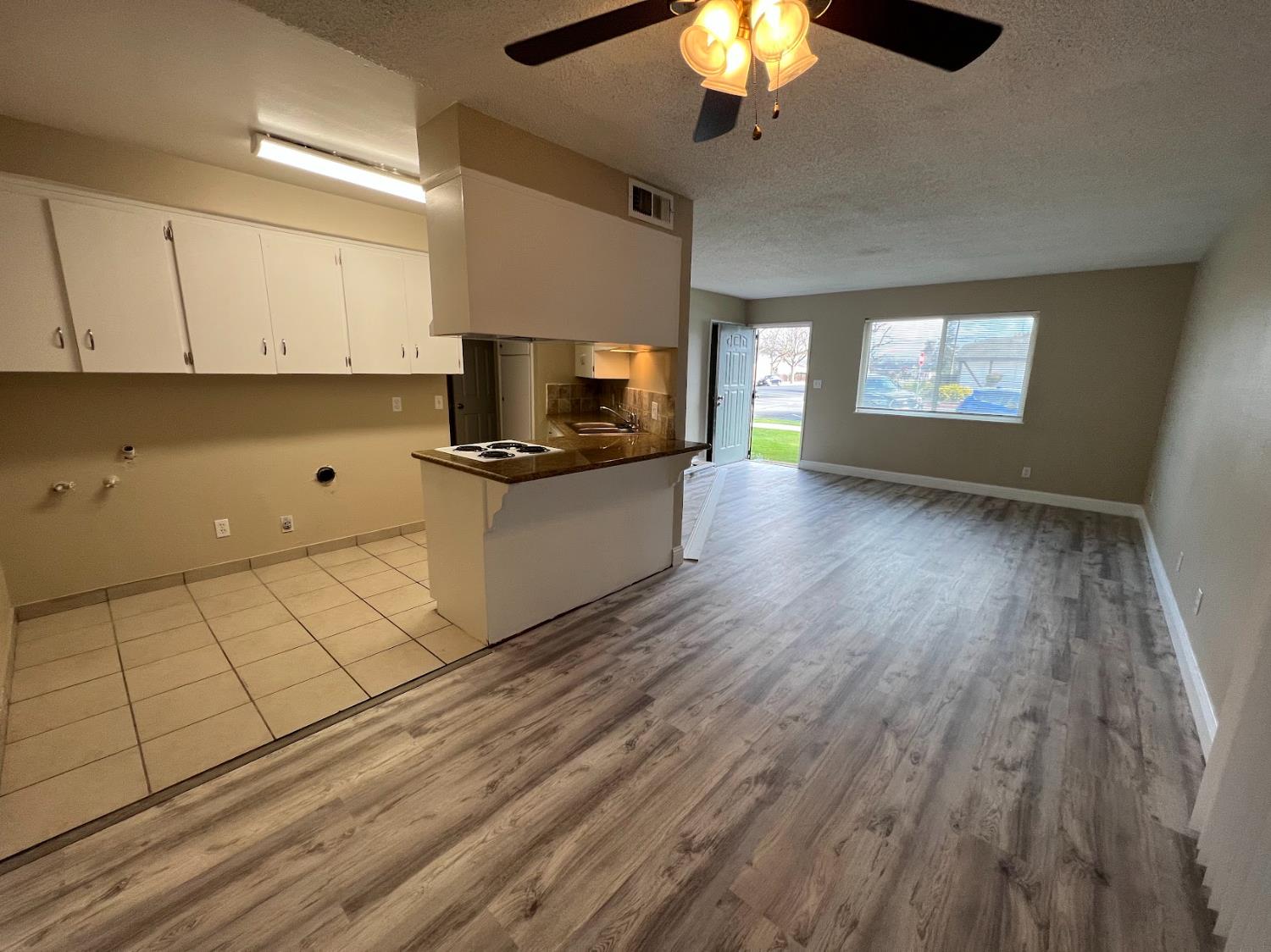 1205 F Street Reedley, CA 93654 - Photo 19 of 34 a kitchen with stainless steel appliances a stove top oven a sink with wooden floors and cabinets
