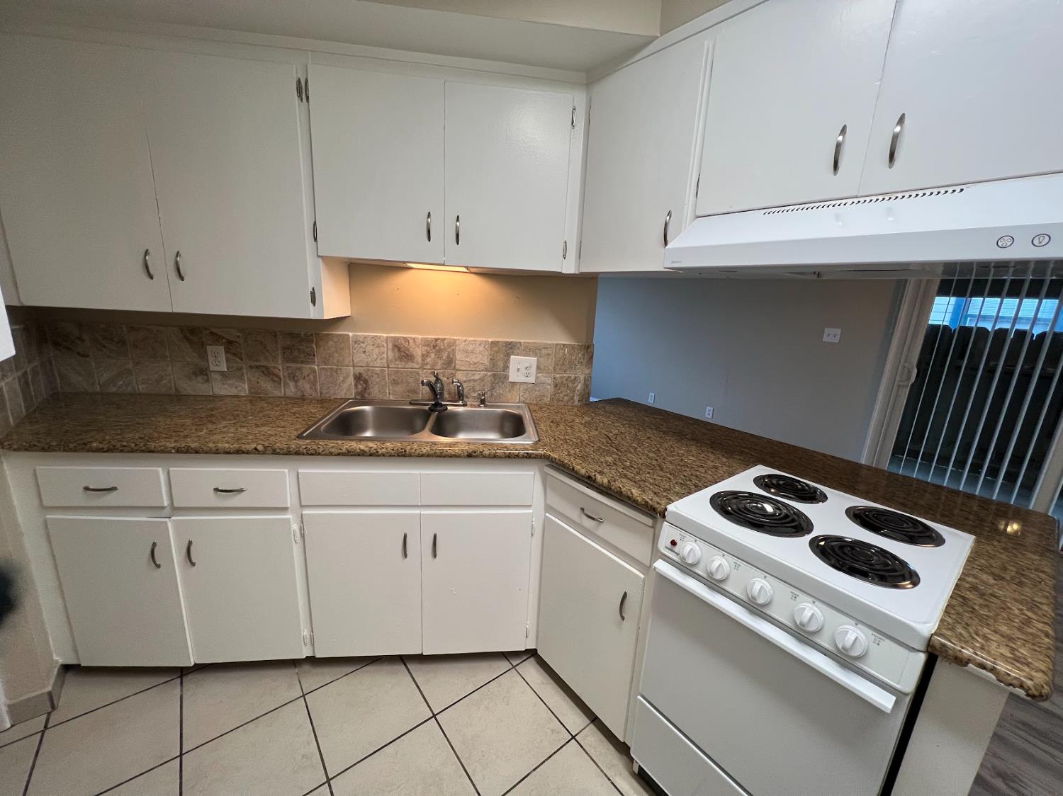 1205 F Street Reedley, CA 93654 - Photo 21 of 34 a kitchen with granite countertop white cabinets and white appliances