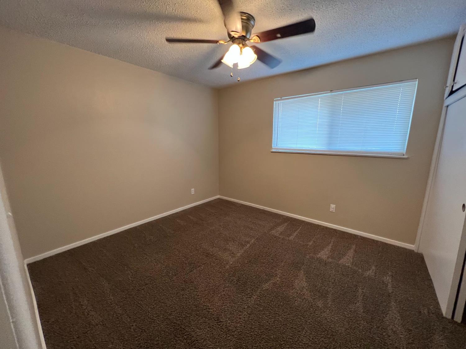 1205 F Street Reedley, CA 93654 - Photo 26 of 34 an empty room with a fan and a window