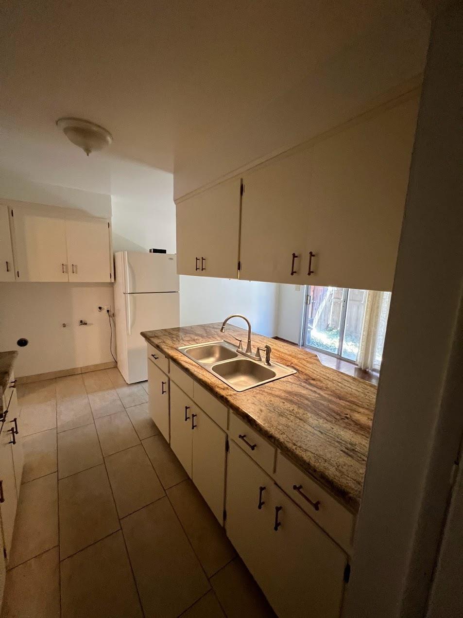 1205 F Street Reedley, CA 93654 - Photo 7 of 34 a view of a kitchen with a sink cabinets and a window