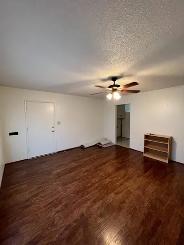 a view of a livingroom with wooden floor and ceiling fan