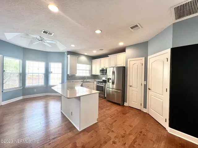a view of kitchen with refrigerator and window