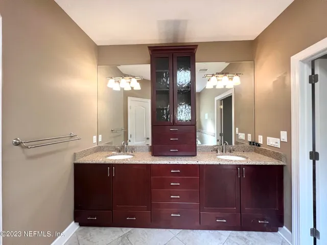 a bathroom with a granite countertop sink and a mirror