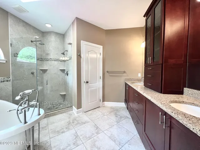 a bathroom with a granite countertop bathtub shower sink and mirror