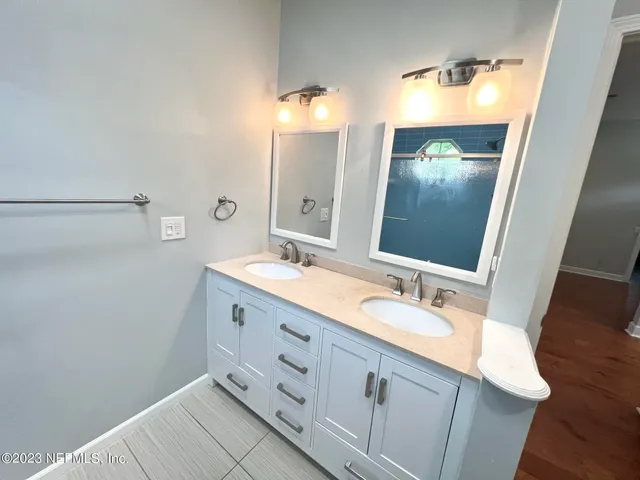 a bathroom with a double vanity sink and a mirror