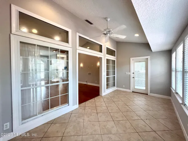 a view of a livingroom with a chandelier fan and windows