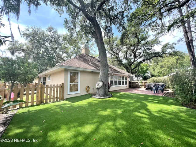 a front view of a house with a garden and trees