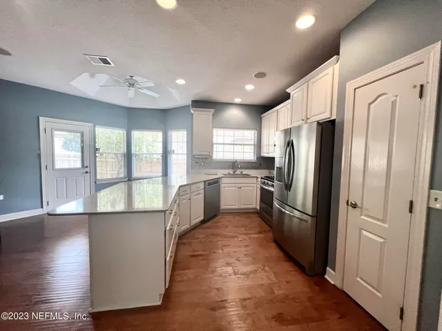 a kitchen with refrigerator a sink and cabinets