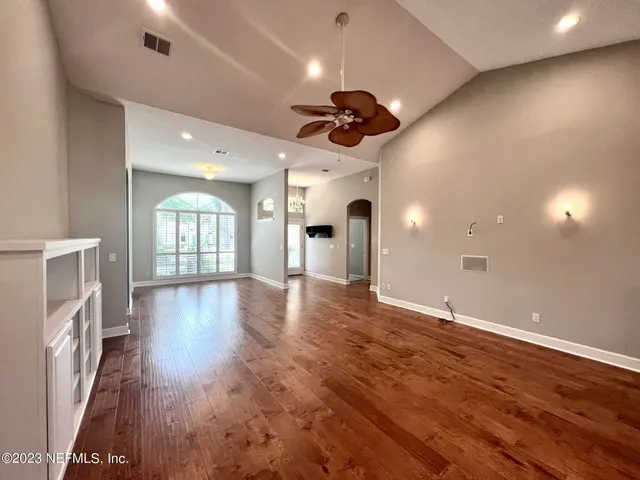 a view of an empty room with a fireplace and a window