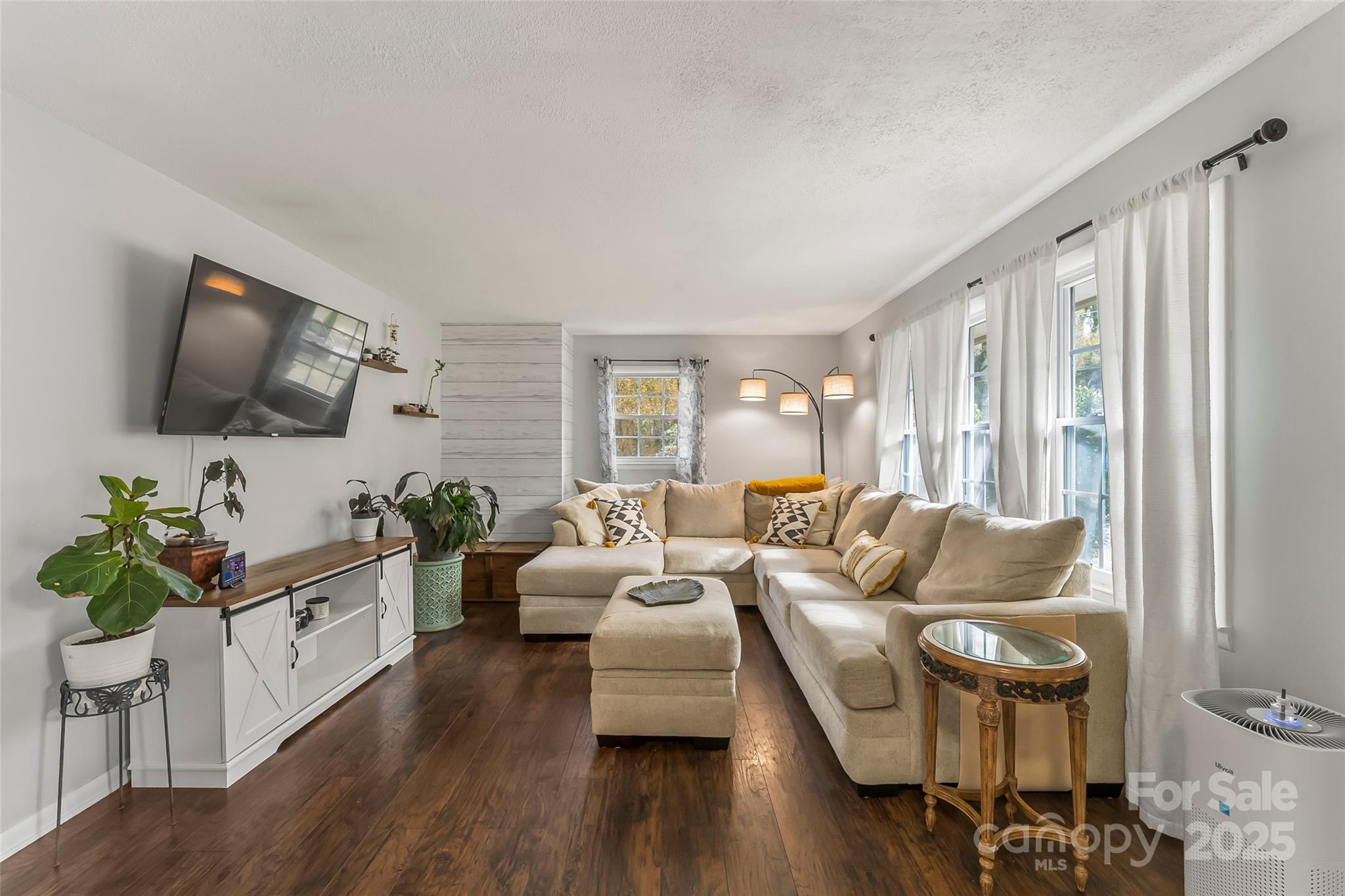 320 Morehead St Extension Morganton, NC 28655 - Photo 5 of 33 a living room with furniture a flat screen tv and a floor to ceiling window