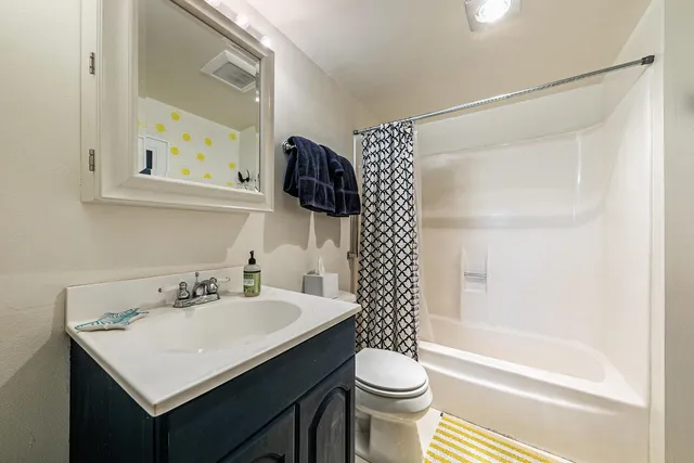 a bathroom with a sink a toilet and shower curtain