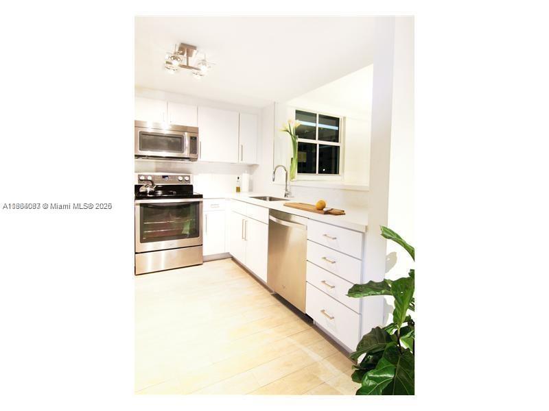 1250 South Miami Avenue, Unit 901 Miami, FL 33130 - Photo 5 of 10 a kitchen with stainless steel appliances a sink and cabinets