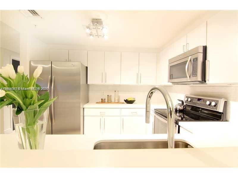 1250 South Miami Avenue, Unit 901 Miami, FL 33130 - Photo 6 of 10 a kitchen with stainless steel appliances a sink a refrigerator a counter top space and cabinets