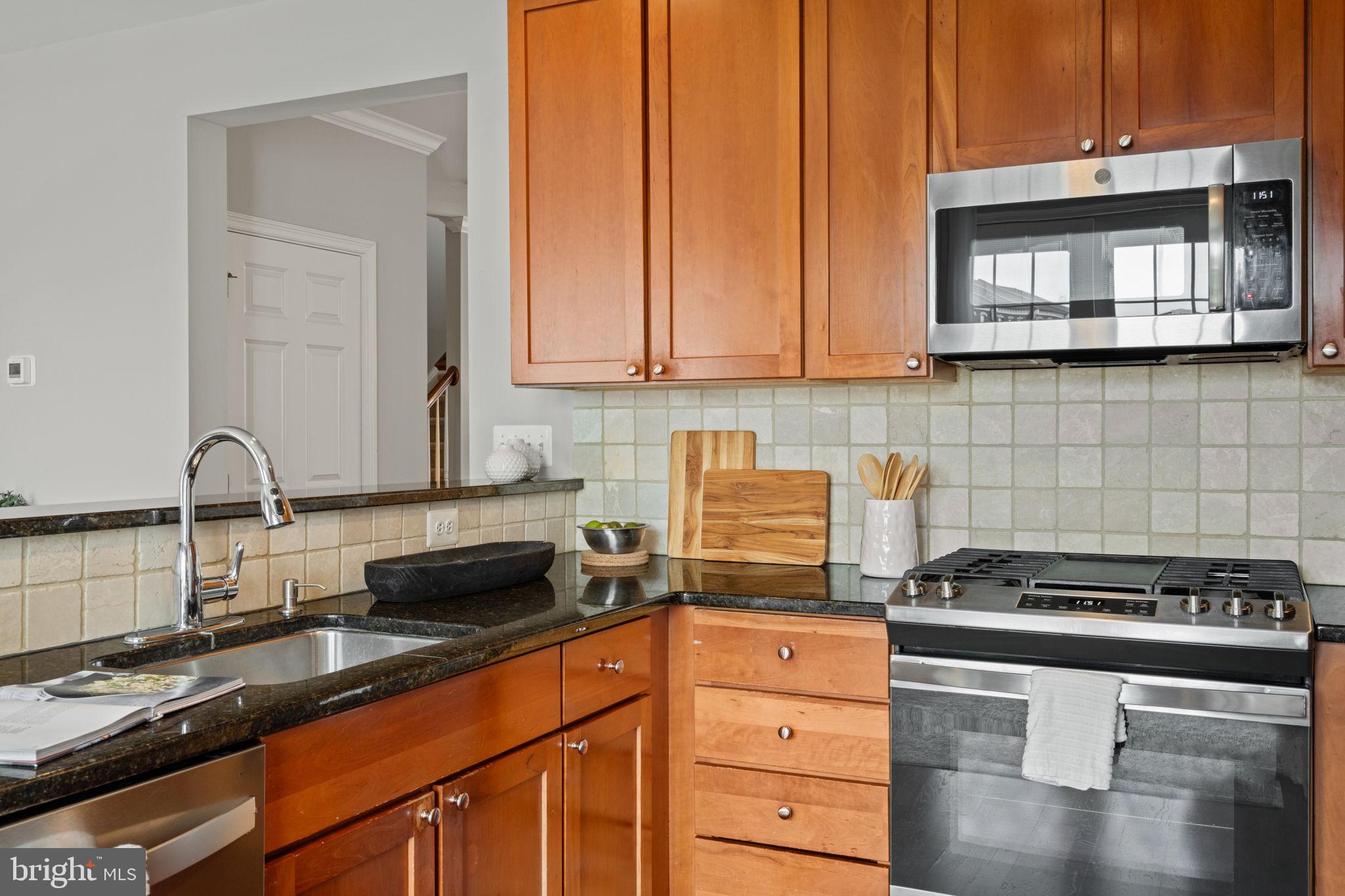 305 Captains Way Philadelphia, PA 19146 - Photo 20 of 63 a kitchen with granite countertop a sink a stove and cabinets