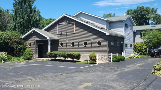 a front view of a house with a yard and potted plants