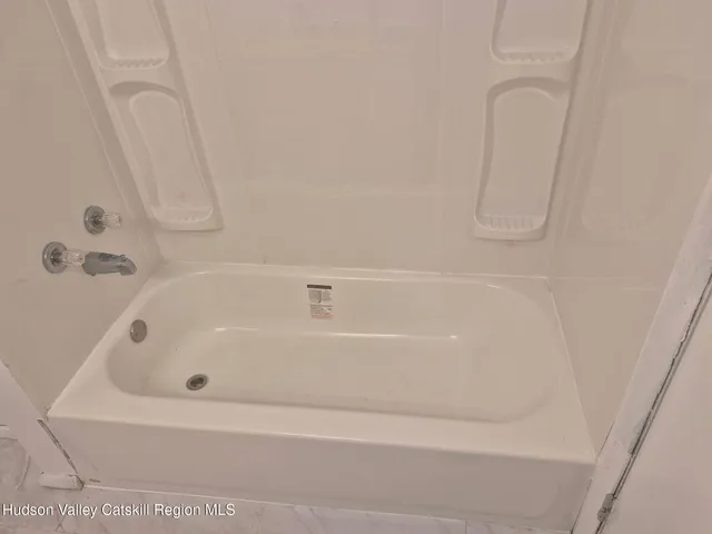 a white bath tub sitting next to a white sink and vanity