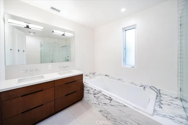 a bathroom with a tub sink and a mirror