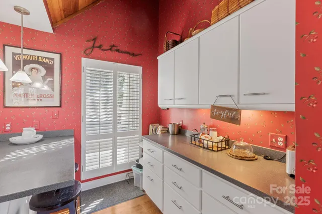 a kitchen with granite countertop white cabinets and window