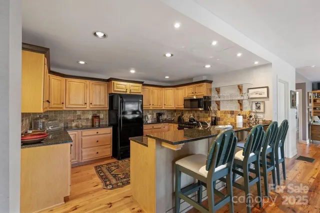 a kitchen with stainless steel appliances kitchen island granite countertop a refrigerator and cabinets