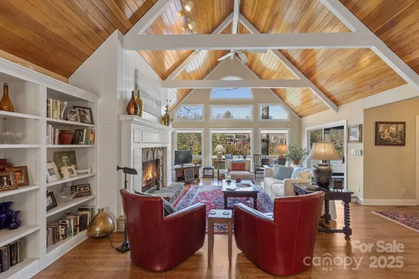 a living room with furniture a flat screen tv and a floor to ceiling window