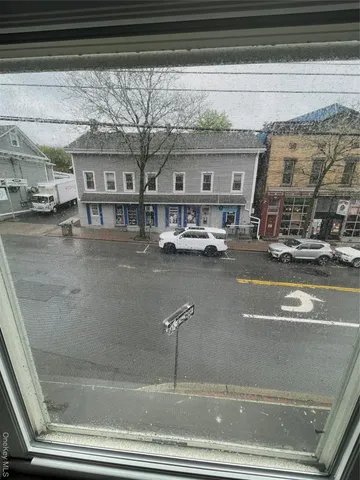 a view of a room with wooden floor and a refrigerator