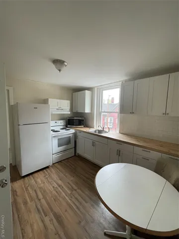 a white stove top oven sitting inside of a kitchen