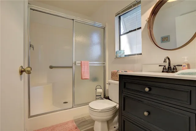 a bathroom with a sink a toilet and shower