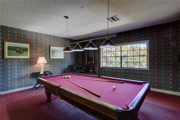 a room with pool table and windows