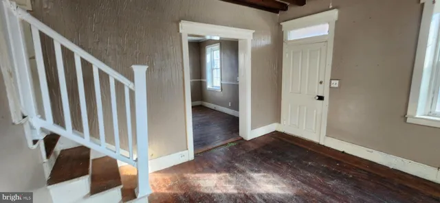 a view of a hallway with wooden floor and staircase