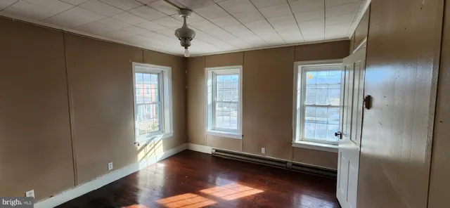 a view of an empty room with wooden floor