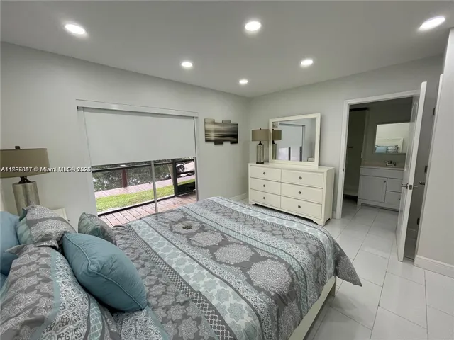 a bed room with a bed and a view of living room