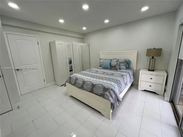 a spacious bedroom with a bed and a mirror