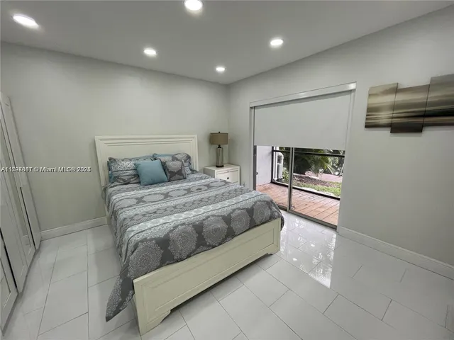 a spacious bedroom with a bed and a television