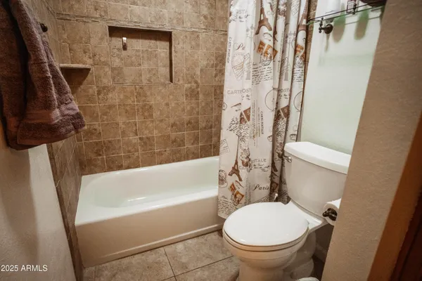 a white toilet sitting next to a bath tub and a shower