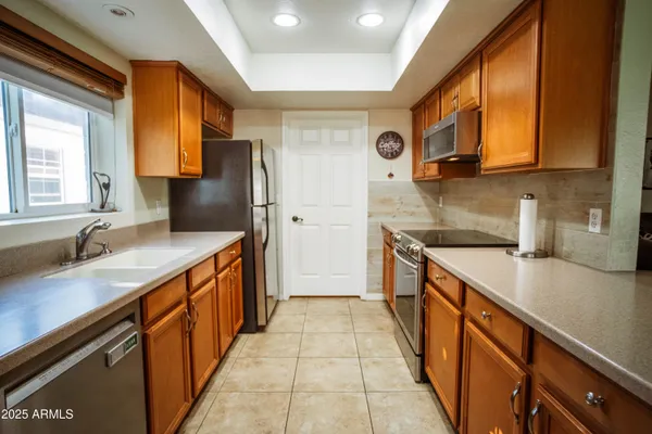 a kitchen with stainless steel appliances granite countertop a sink and a refrigerator