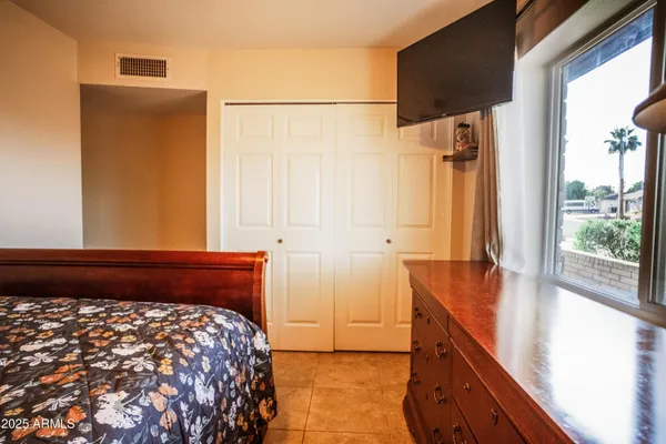 a bedroom with a bed and a dresser next to a window