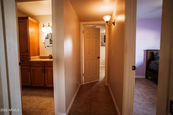 a view of a hallway with bathroom and mirror