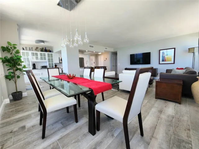 a living room with furniture a potted plant and a large window