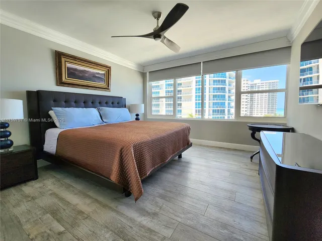 a bedroom with a bed and a flat screen tv on dresser