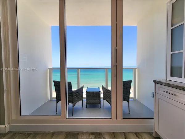 a kitchen with stainless steel appliances granite countertop a stove a sink dishwasher a refrigerator and a dining table with wooden floor