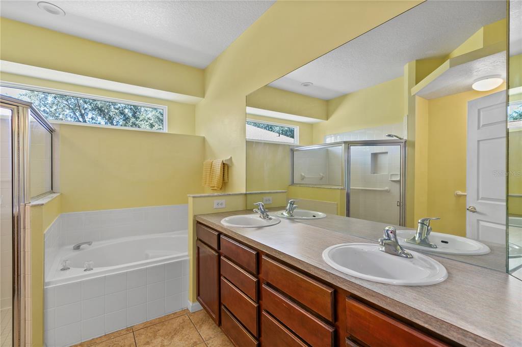 13320 Via Roma Circle Clermont, FL 34711 - Photo 13 of 26 a bathroom with a granite countertop sink and a bathtub