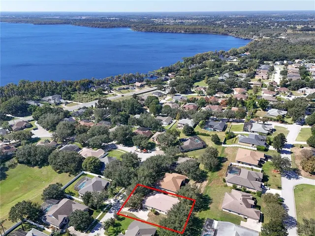 an aerial view of ocean and residential houses with outdoor space