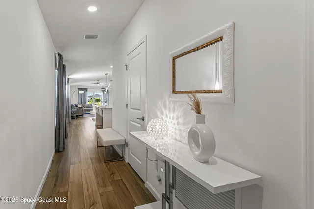 a kitchen with a sink a stove a refrigerator and white cabinets with wooden floor