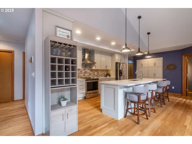 a living room with stainless steel appliances kitchen island granite countertop furniture wooden floor and a kitchen view