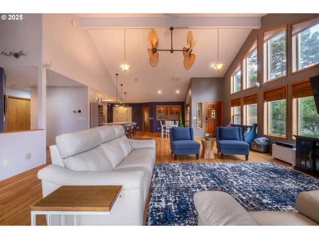 a living room with furniture kitchen view and a large window