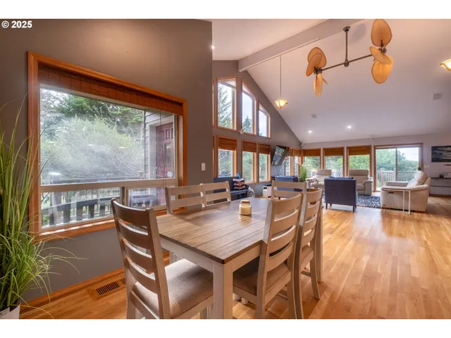 a dining room with wooden floor and a large window