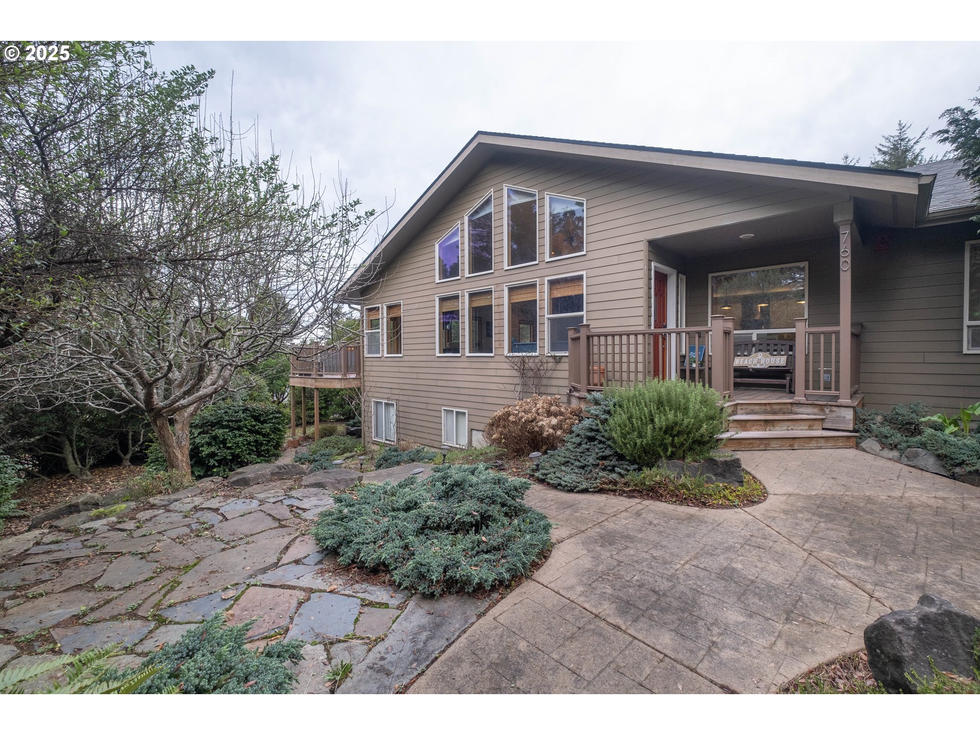 760 Southwest Range Drive Waldport, OR 97394 - Photo 2 of 30 a front view of a house with garden