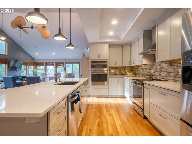 a kitchen with stainless steel appliances granite countertop a sink a stove and cabinets